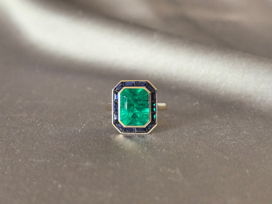 GR-002| Lab-Grown Emerald Center Stone | Baguette-Cut Blue Sapphire Accents | Bezel Set | Geometric Halo Frame |Anniversary & Milestone Gift