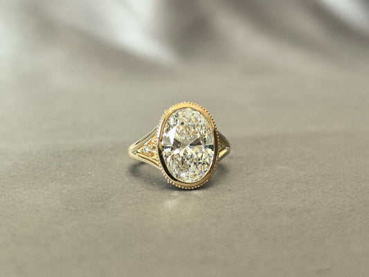 Oval-shaped ring setting | Lab-created diamond | Small diamonds of varying sizes set on the sides and bottom | Split shank | Vintage Athenian style design