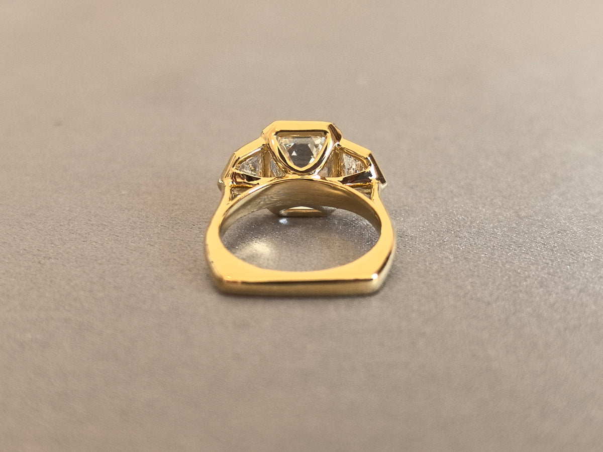 Juno Diamond EM-032 | 5 Carat Emerald-Cut Lab-Grown Diamond Three-Stone Full-Bezel Ring with Trapezoid Side Stones