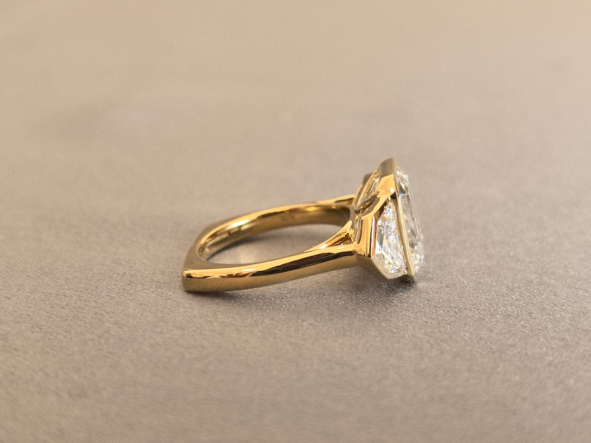 Juno Diamond EM-032 | 5 Carat Emerald-Cut Lab-Grown Diamond Three-Stone Full-Bezel Ring with Trapezoid Side Stones